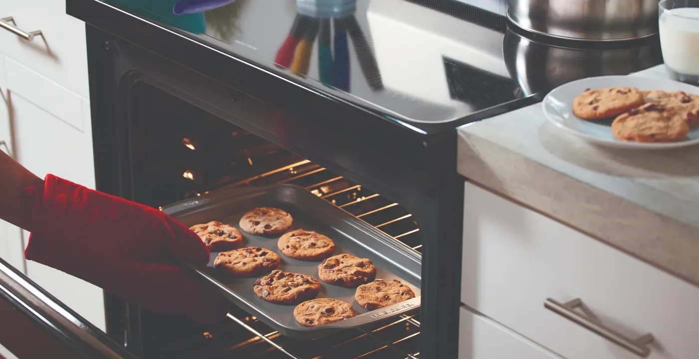 lady taking cookies out of oven